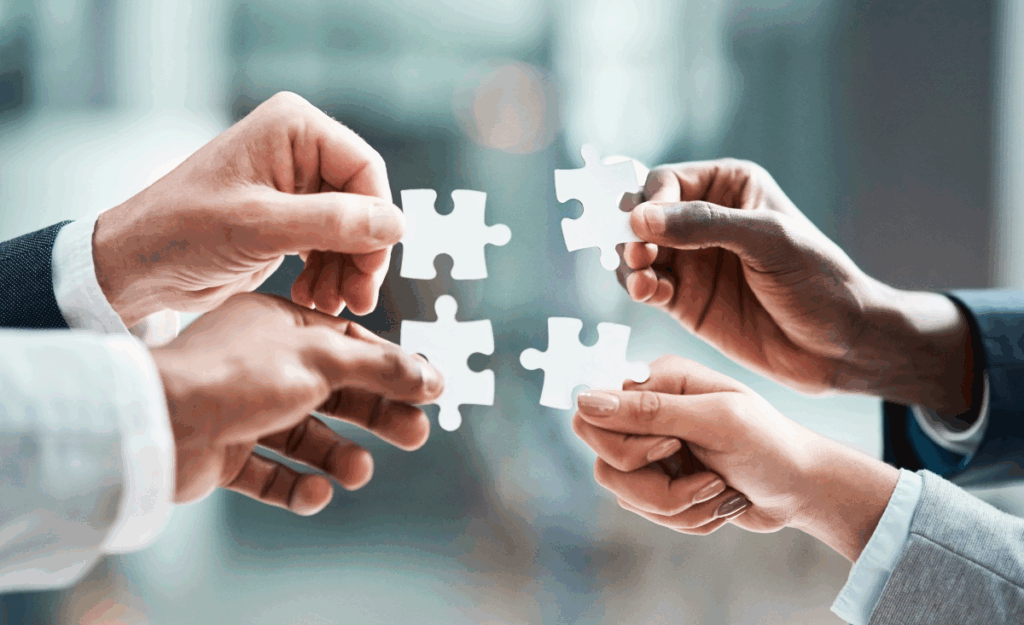 Puzzle avec 4 mains symbolisant les pièces qui s'emboitent grâce à l'accompagnement en audit fiscal de Cemafa